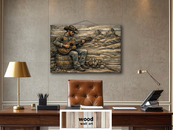 Rustic cowboy playing guitar wood wall art on a distressed panel above a leather office desk.