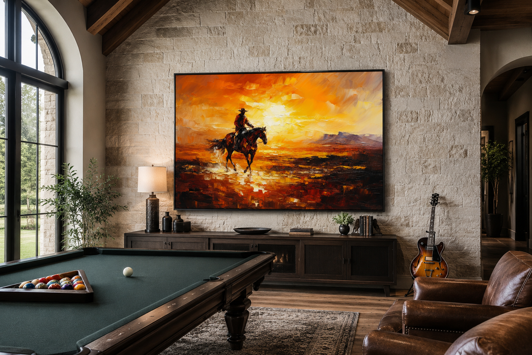 Large canvas art of a cowboy riding a horse in a desert at sunset, hung in a rustic game room.