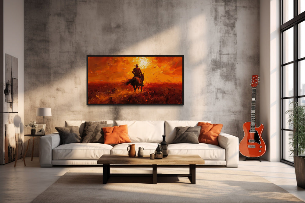 Cowboy Riding Into Sunset Western Canvas Wall Art in a living room with a couch a guitar