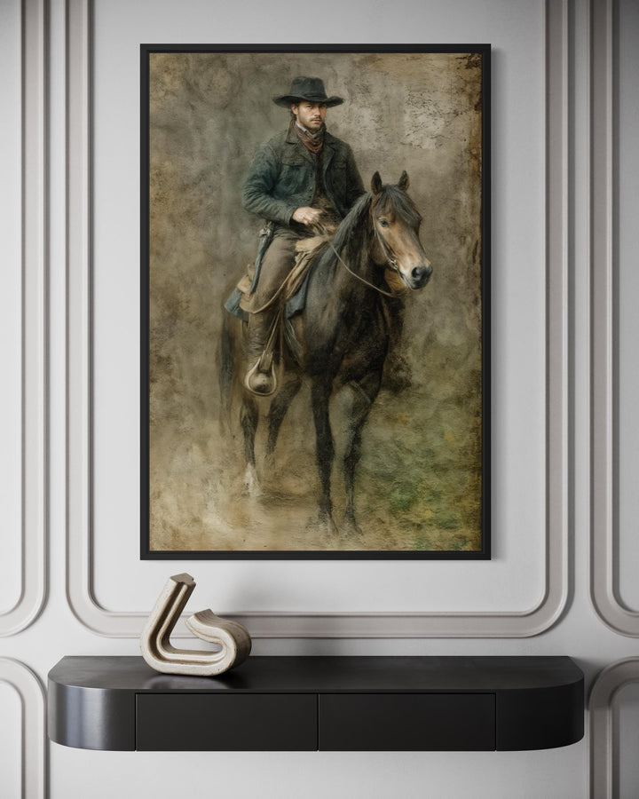 Framed vintage-style canvas print of a cowboy on horseback above a modern black console table.