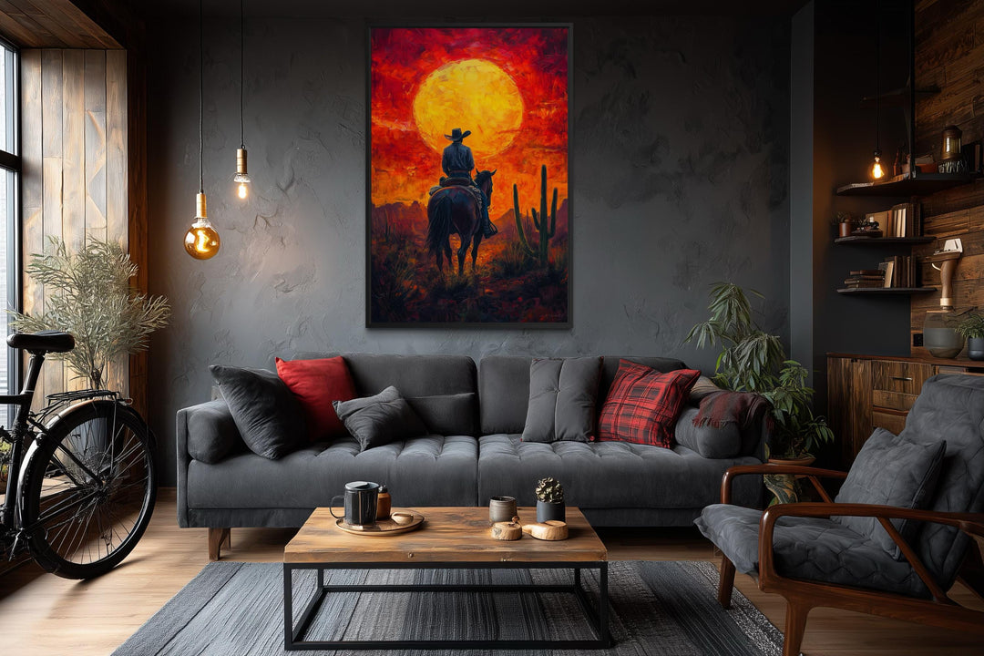 A framed canvas print of a cowboy on horseback silhouetted against a fiery orange desert sunset.