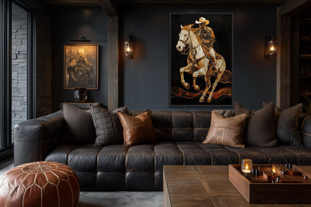 A vertical canvas painting of a cowboy on a rearing horse in gold and bronze tones on a black wall.