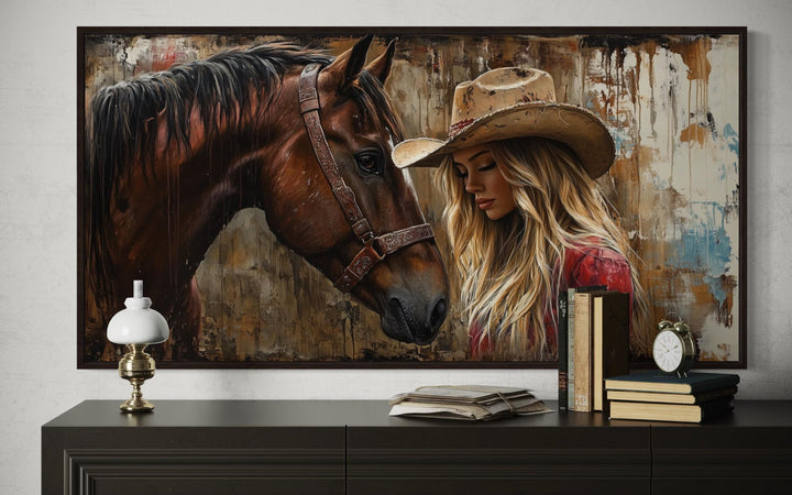 Framed graffiti-style canvas art of a cowgirl and horse above a dark wood console table.