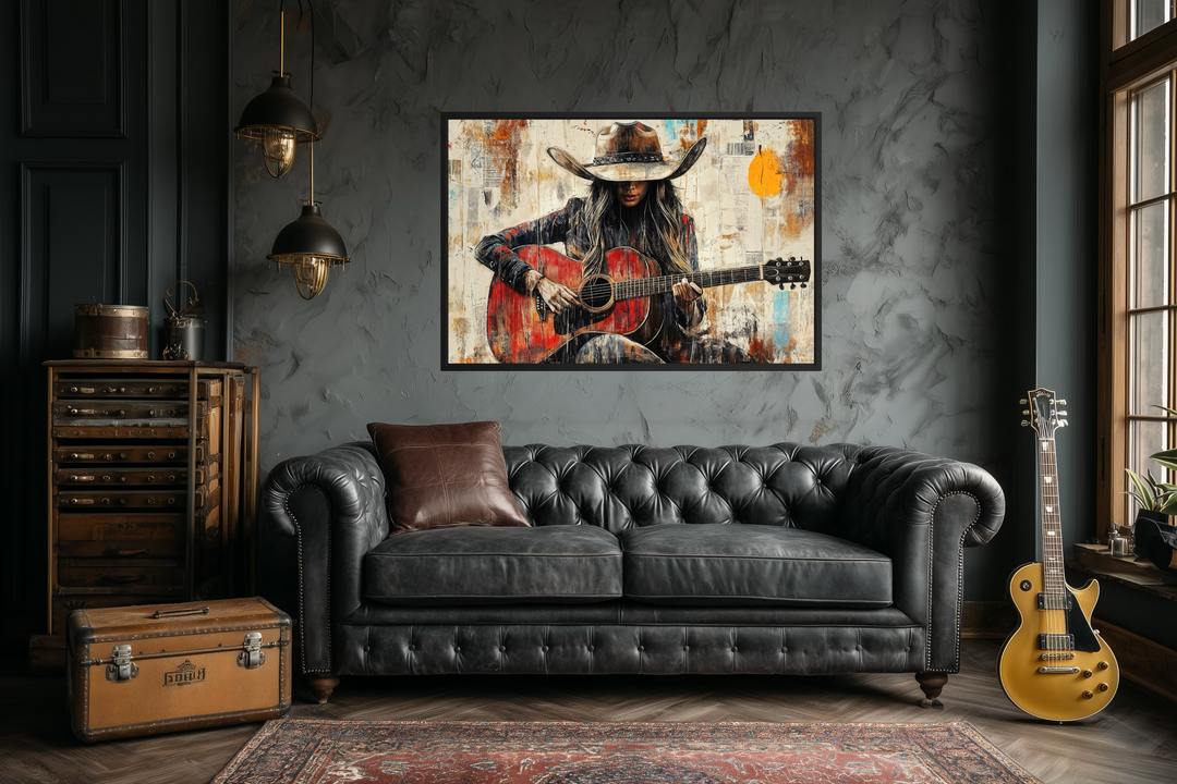 Framed canvas wall art of a cowgirl playing a red guitar in a rustic, textured painting style.