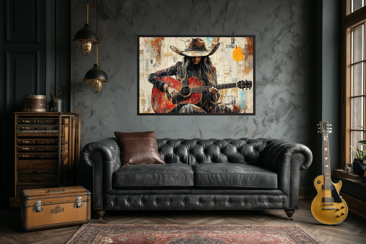 Framed canvas wall art of a cowgirl playing a red guitar in a rustic, textured painting style.