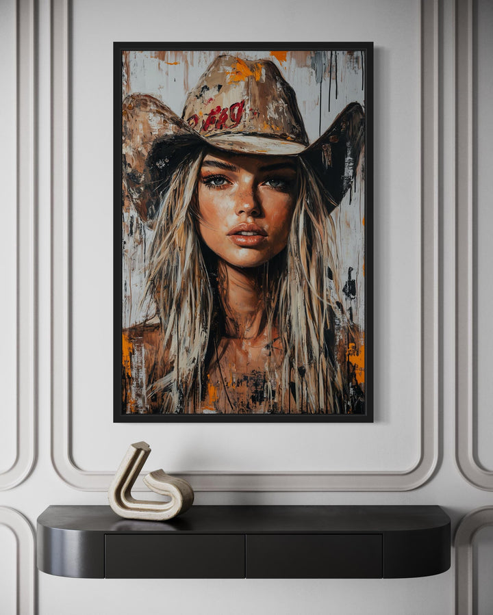 Cowgirl rustic graffiti portrait framed canvas wall art hanging above a dark console table.