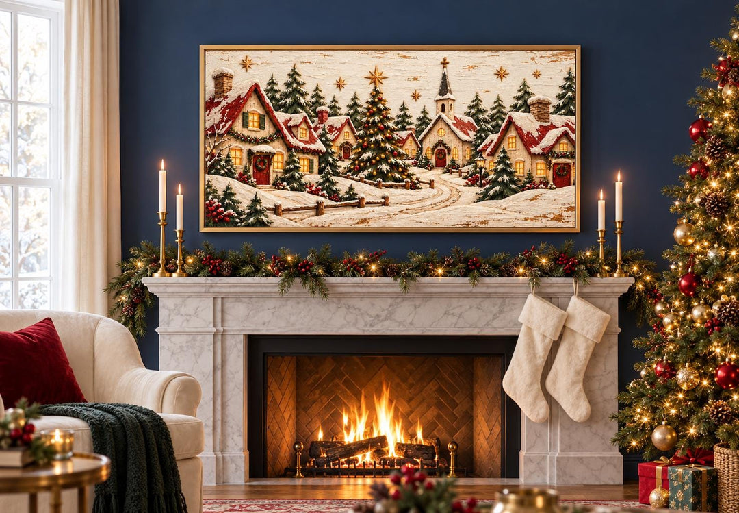 Framed canvas wall art of a snowy Christmas village with cottages and a church above a fireplace.