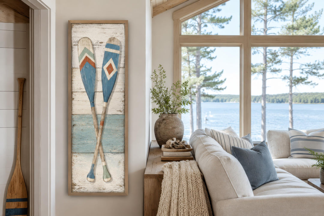 Tall narrow canvas wall art featuring two crossed rustic oars in blue and cream on a wood backdrop.