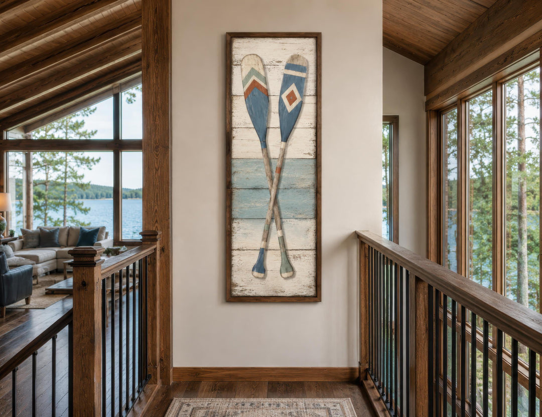 Tall narrow canvas wall art featuring two crossed weathered oars in a rustic lake house hallway.