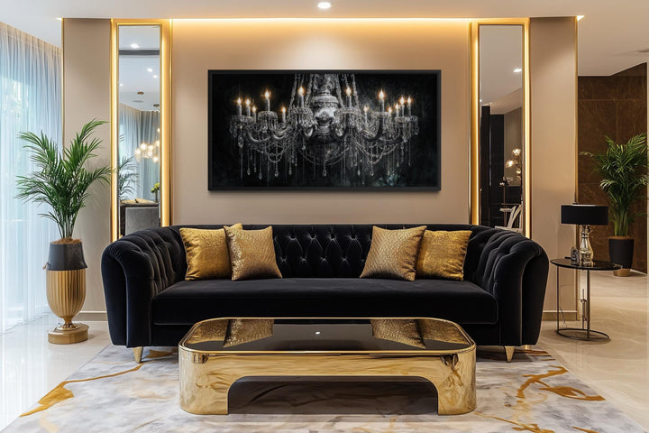 Large horizontal canvas wall art of a crystal chandelier hanging above a black velvet sofa.