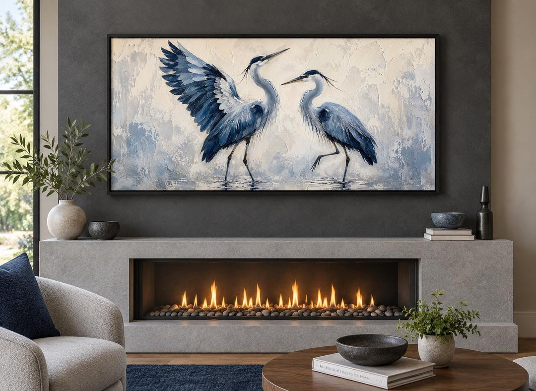 Dancing Blue Herons navy and cream canvas wall art displayed above a modern fireplace.