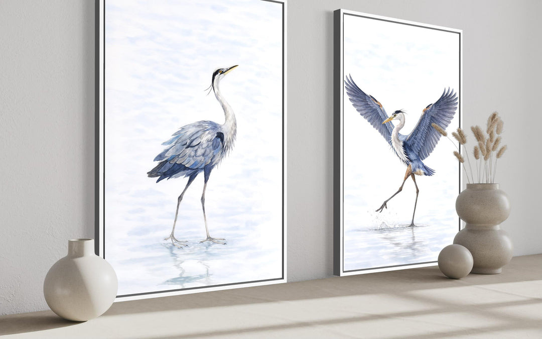 Set of two watercolor heron canvas prints in white frames, featuring blue and gray birds.