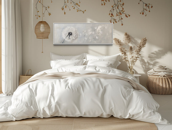 Horizontal framed canvas wall art featuring a white dandelion on a grey background above a bed.
