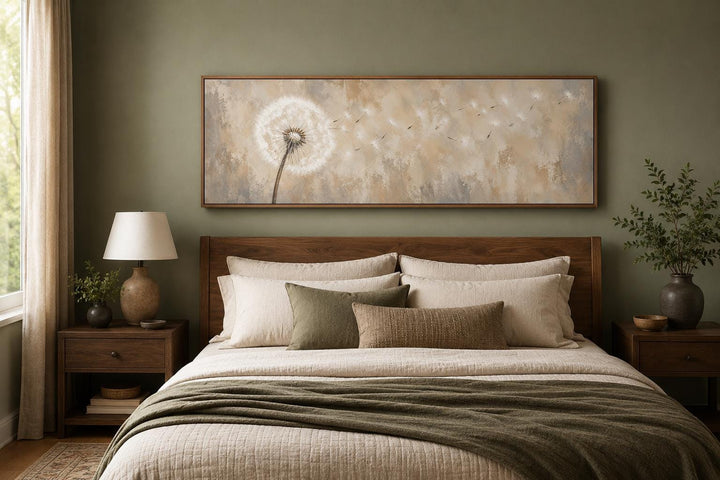 Dandelion seeds blowing in wind long horizontal neutral canvas wall art above a wooden bed frame.