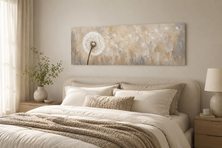 Long horizontal neutral dandelion wall art hanging above a bed in a minimalist bedroom.