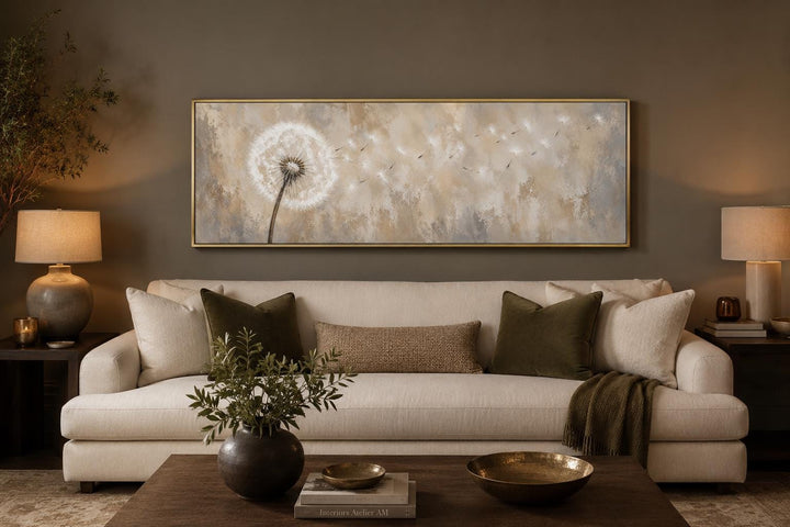 Long horizontal dandelion seeds wall art in neutral tones hanging above a sofa in a living room.