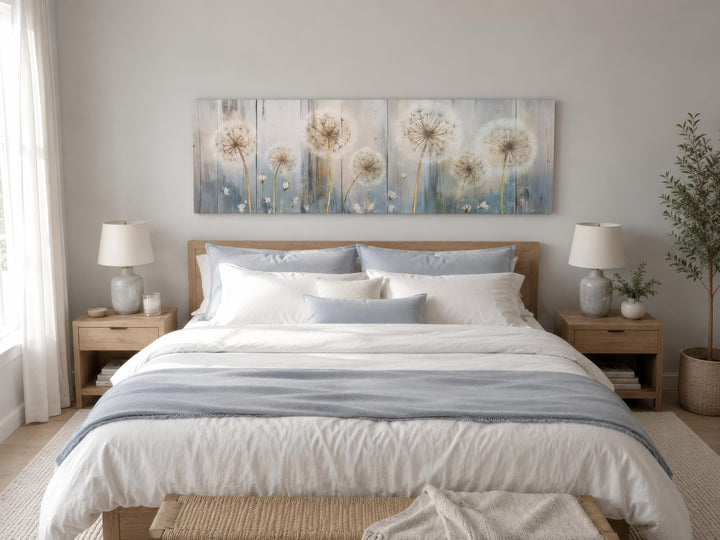 Long horizontal dandelion canvas wall art in muted blue and cream tones above a farmhouse bed.