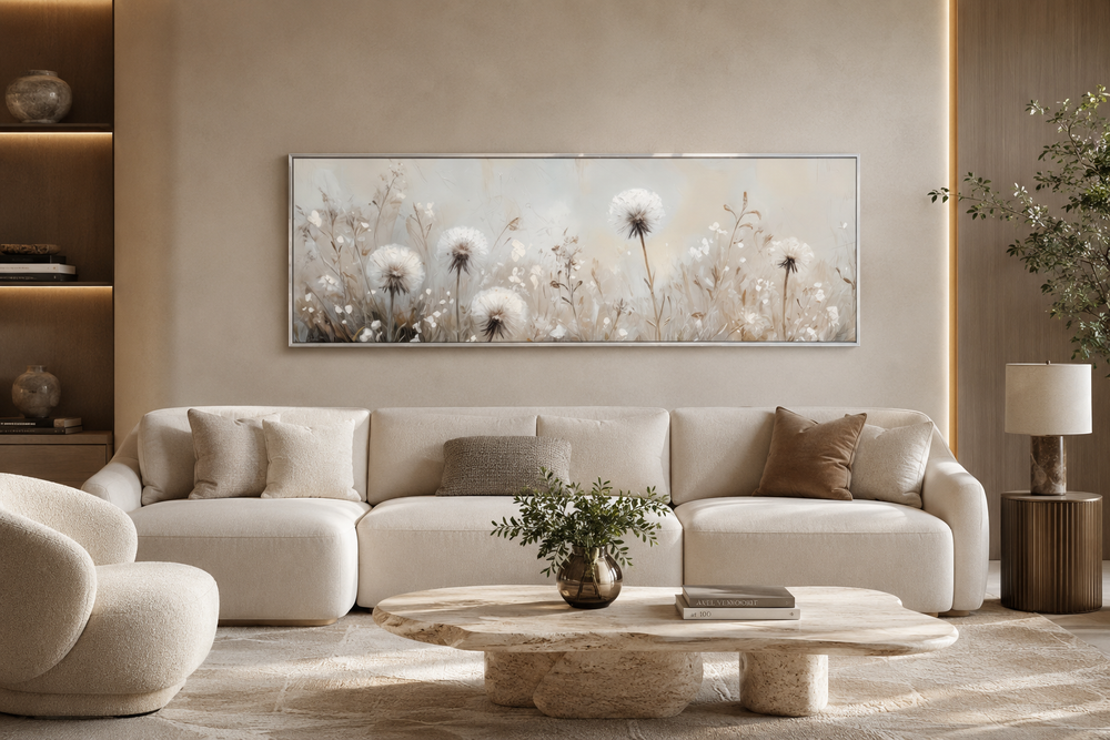 Long horizontal wall art of white dandelions in a neutral field above a beige sofa.