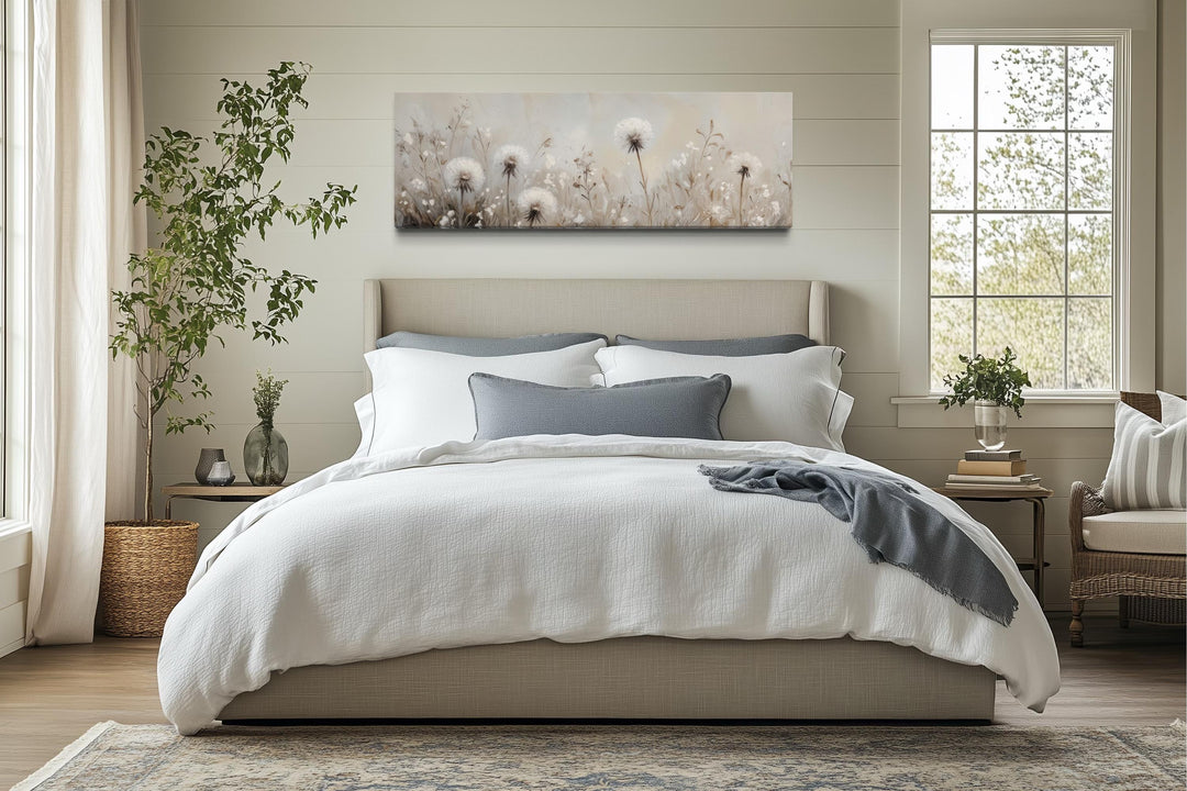 Long horizontal wall art of white dandelions in a neutral field above a bed in a farmhouse bedroom.