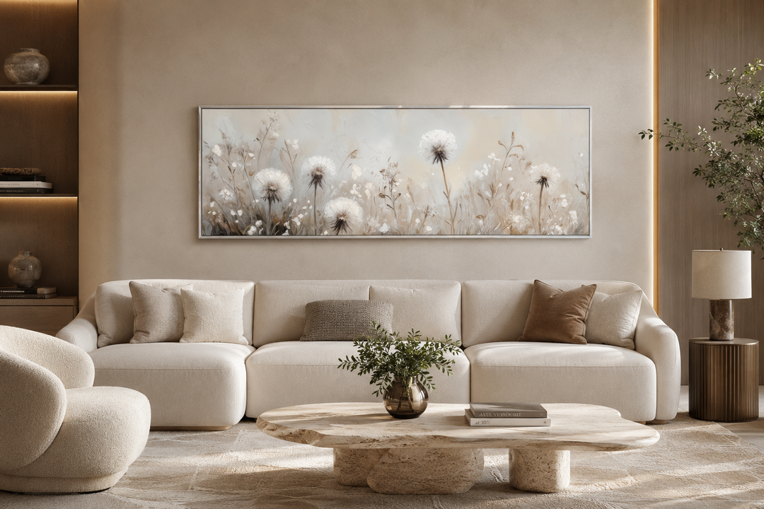 Long horizontal wall art of white dandelions in a neutral field above a beige sofa.