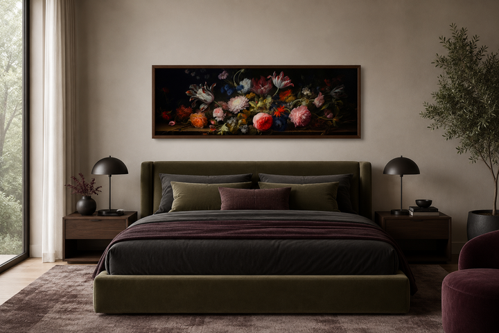 Moody horizontal framed canvas wall art featuring antique flowers above a bed in a dark bedroom.