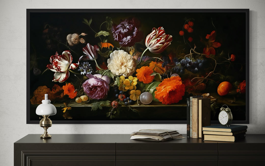 Framed dark academia floral canvas art above a dark console with books, a lamp, and an alarm clock.