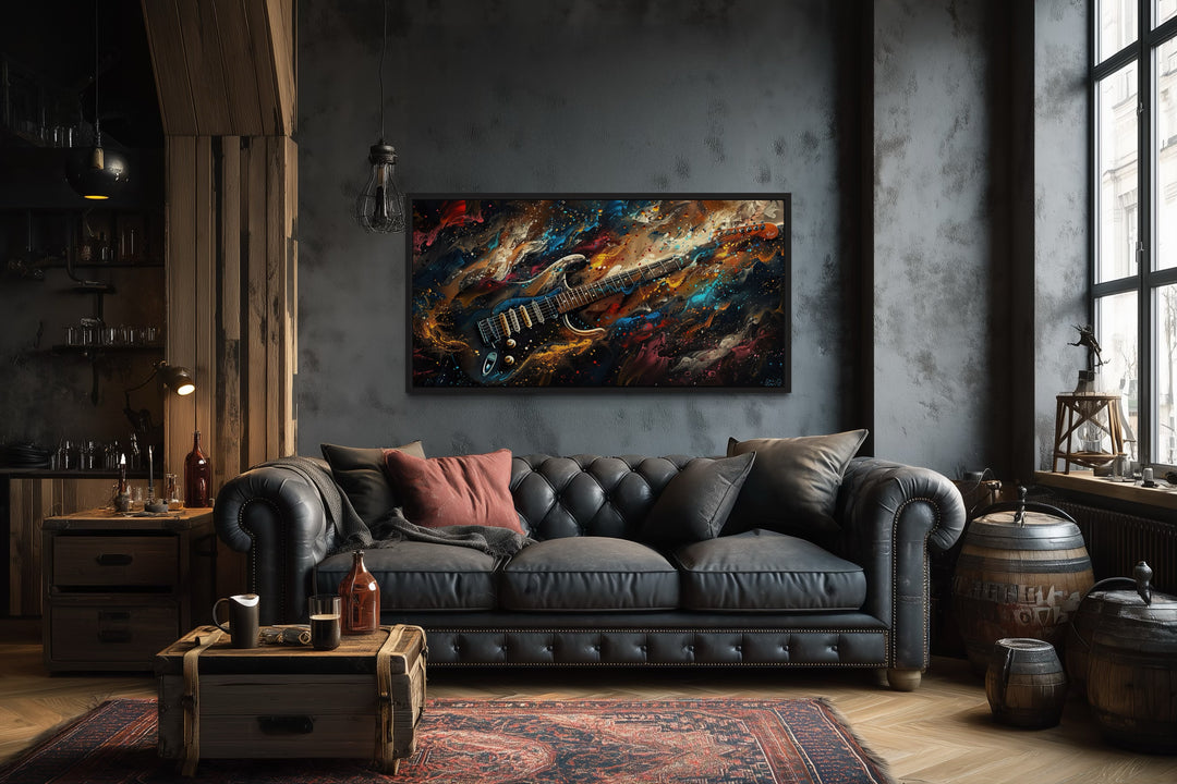 Dark colorful electric guitar framed canvas wall art above a black leather sofa in a music room.