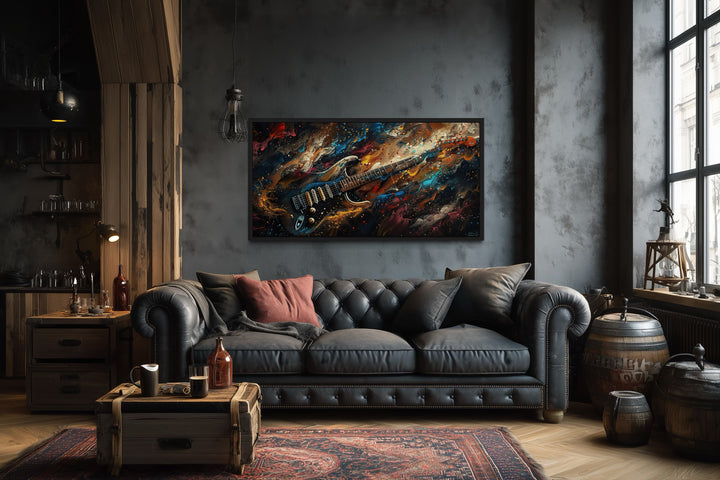 Dark colorful electric guitar framed canvas wall art above a black leather sofa in a music room.