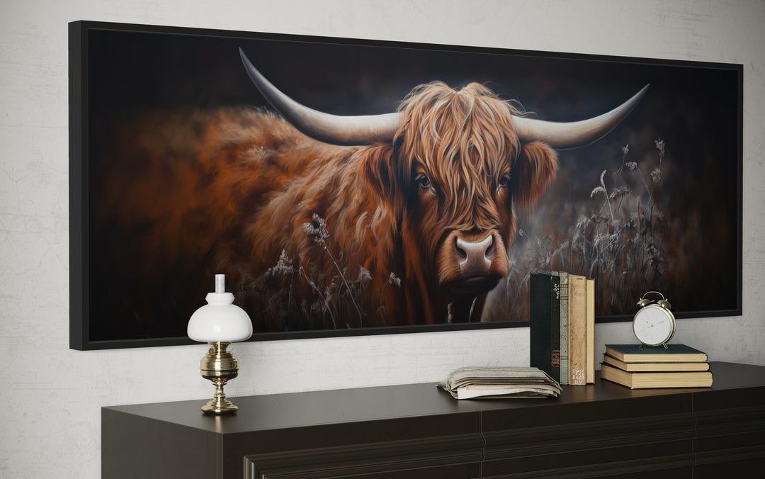 Long horizontal canvas wall art of a dark Highland cow with large horns above a dark wood dresser.