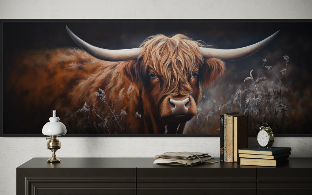 Long horizontal canvas wall art of a dark Highland cow with large horns above a dark wood dresser.
