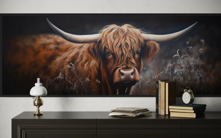 Long horizontal canvas wall art of a dark Highland cow with large horns above a dark wood dresser.
