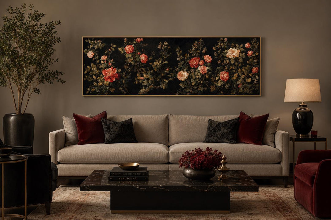 Long horizontal canvas art of red and cream roses on a dark background above a beige sofa.