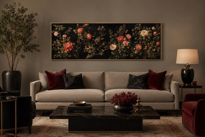 Long horizontal canvas art of red and cream roses on a dark background above a beige sofa.