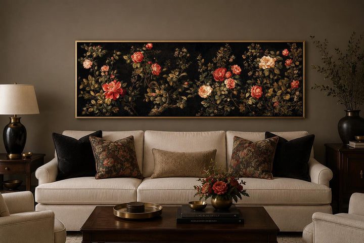 Long horizontal canvas print of red and cream roses on a dark background above a cream sofa.