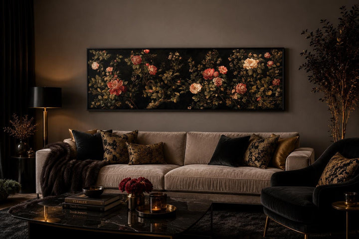 Long horizontal canvas print of red and cream roses on a dark background above a velvet sofa.