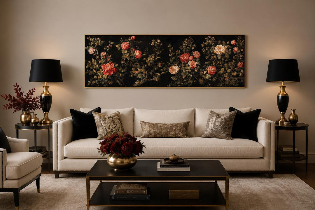 Long horizontal dark moody floral canvas art with red and cream roses above a cream sofa.