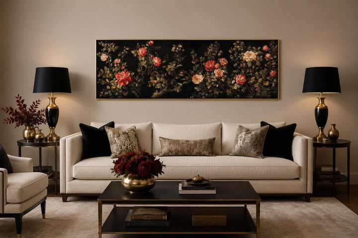 Long horizontal dark moody floral canvas art with red and cream roses above a cream sofa.