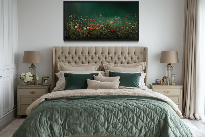 Dark moody green wildflowers field at night framed canvas wall art hanging above a tufted bed.