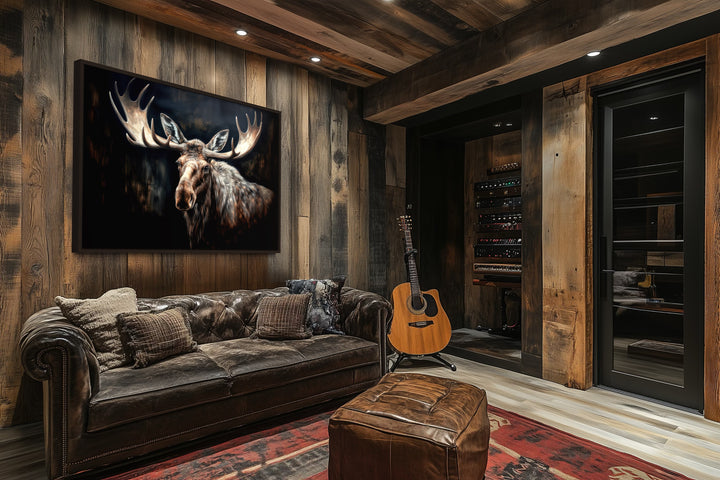 Dark Moose Painting Framed Canvas Wall Art in a rustic cabin living room above a leather sofa.