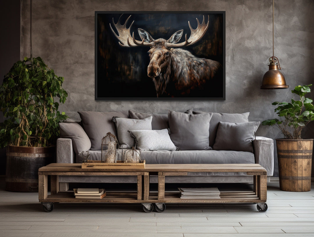 Framed canvas wall art of a moose against a dark background in a rustic living room.