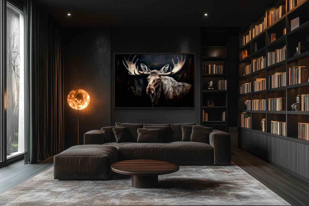 Framed moose canvas wall art in a dark, modern living room with a large bookshelf and sofa.