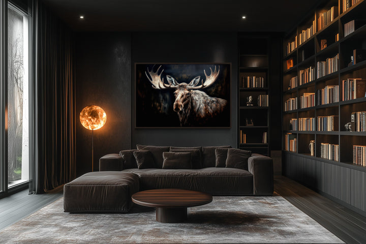 Framed moose canvas wall art in a dark, modern living room with a large bookshelf and sofa.