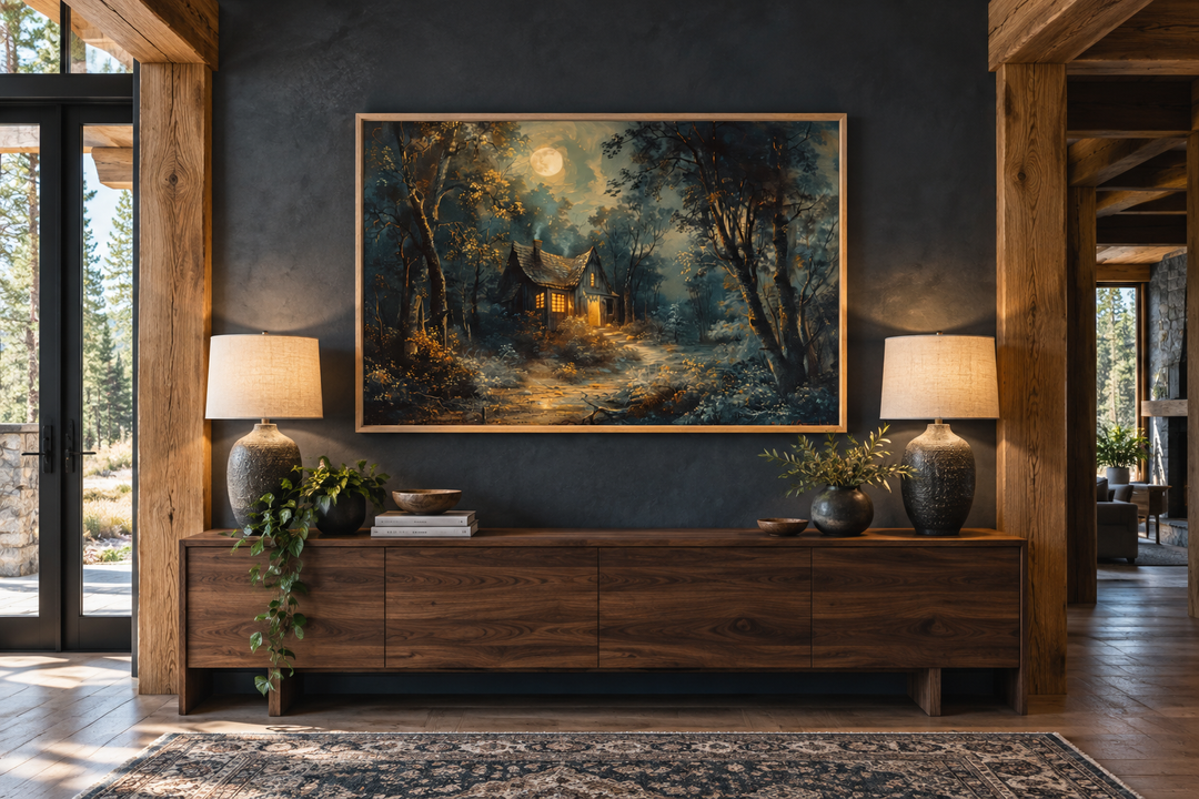 Haunted cabin in a dark forest under a full moon framed wall art above a wooden sideboard.