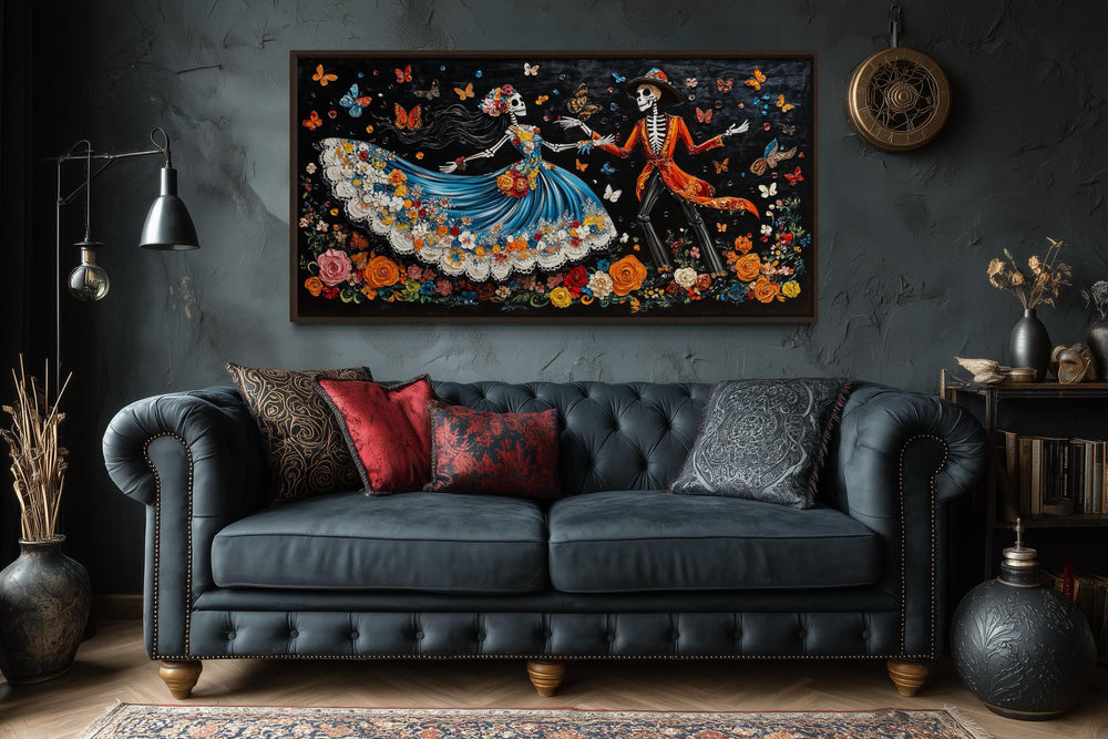 Day of the Dead dancing skeletons canvas wall art hanging above a dark tufted sofa.
