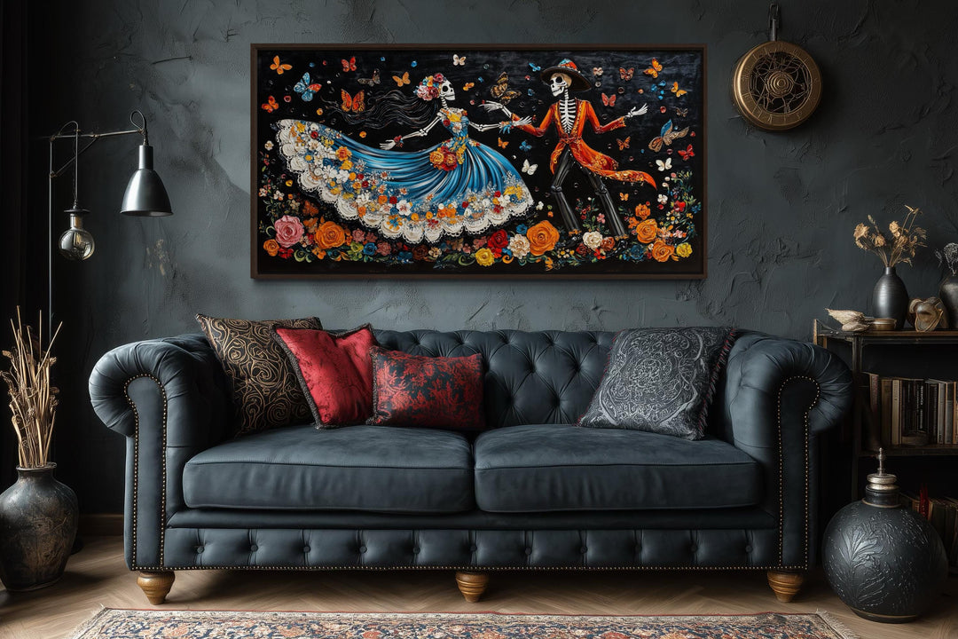 Day of the Dead dancing skeletons canvas wall art hanging above a dark tufted sofa.