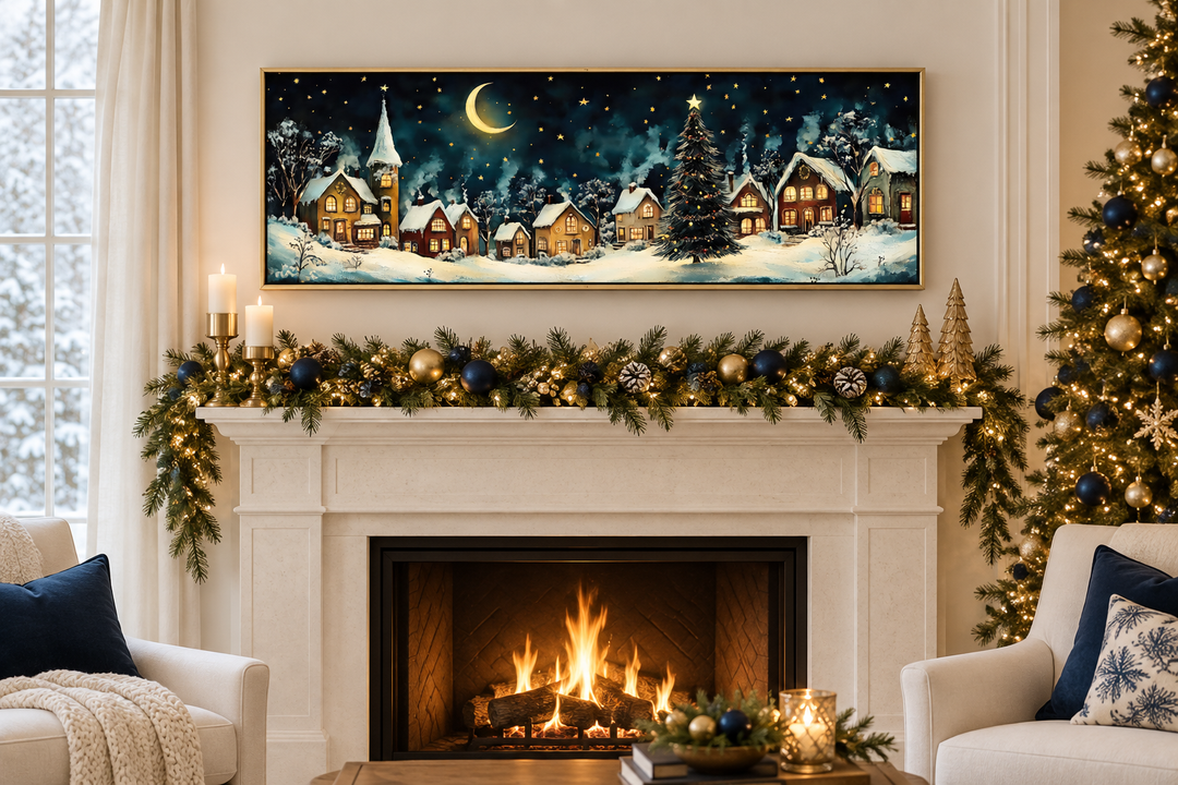Long narrow framed canvas art of a snowy Christmas village at night above a decorated mantel.