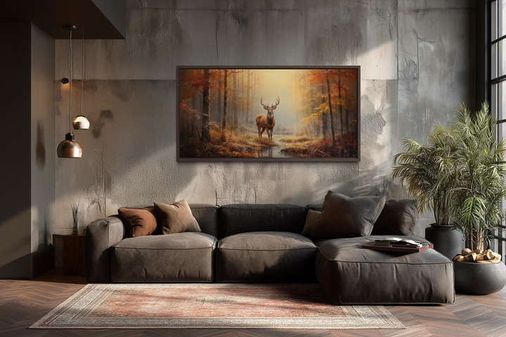 Large framed canvas print of a majestic stag in an autumn forest above a modern brown sofa.