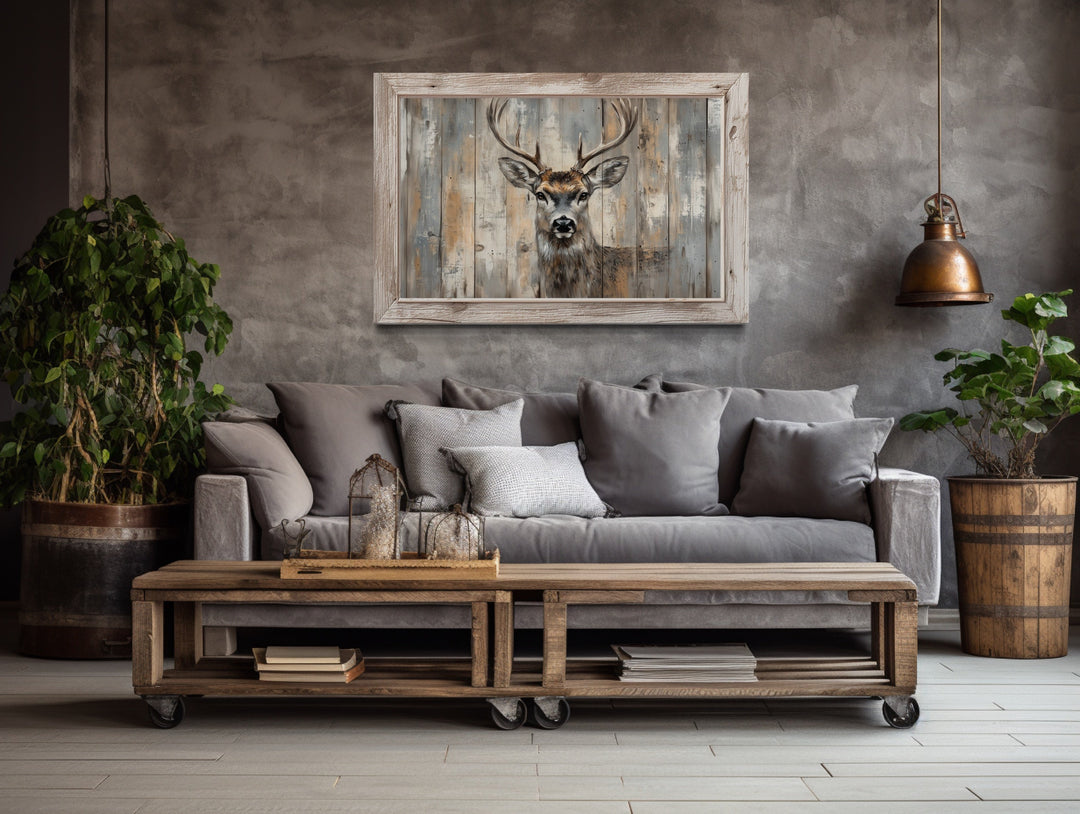 Framed deer canvas wall art with a rustic barnwood background hanging above a gray sofa.