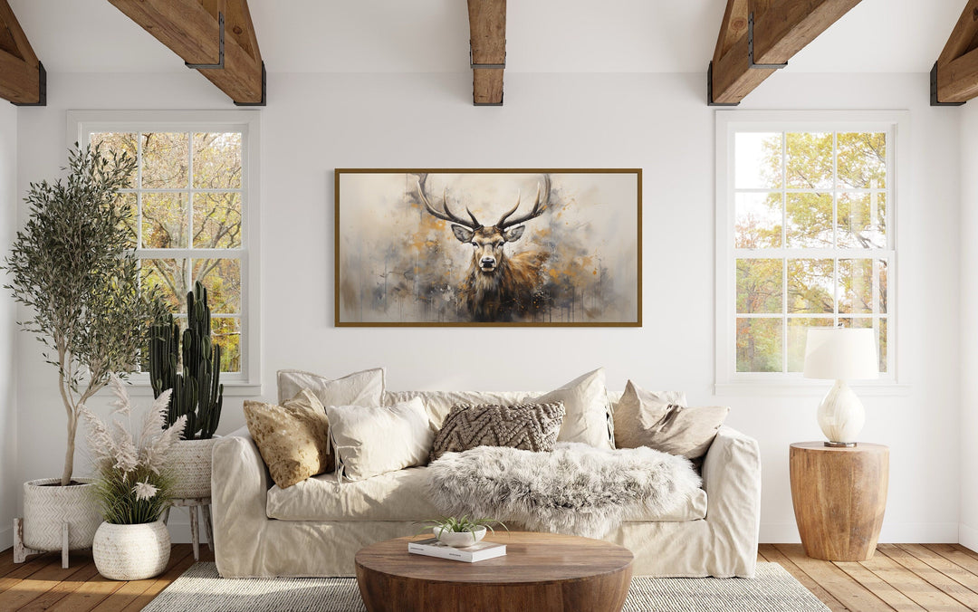 Extra large framed canvas of a majestic deer in a rustic, modern living room above a beige sofa.