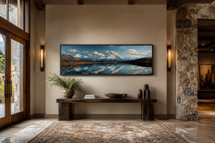 Panoramic wall art of Denali and Wonder Lake reflection above a rustic wooden bench in a room.